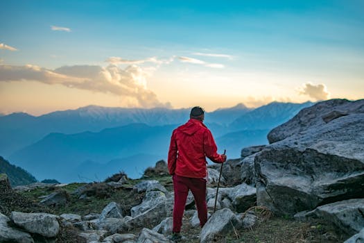 Adventurous hiker in red exploring mountain landscape at sunset.