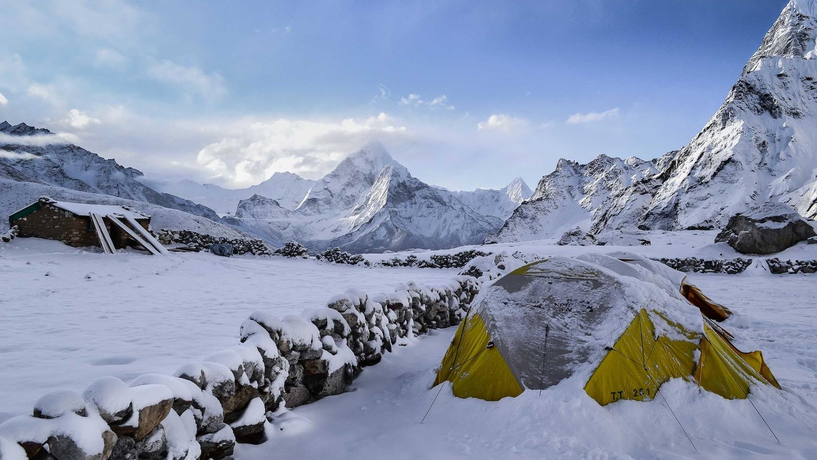 Snow-covered mountain peaks with a tent at a Himalayan base camp